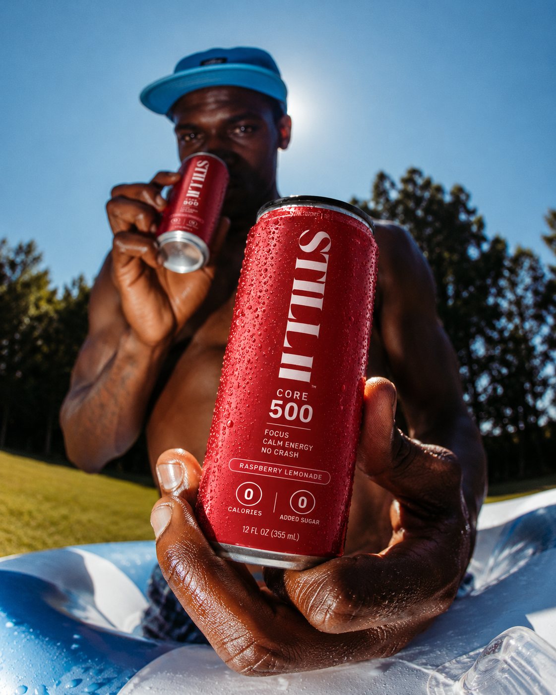 Man holding a can of STILL CORE 500 Raspberry Lemonade poolside