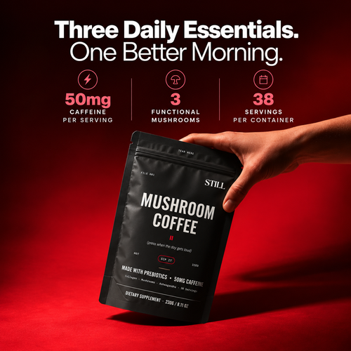 Hand holding a black STILL Mushroom Coffee pouch