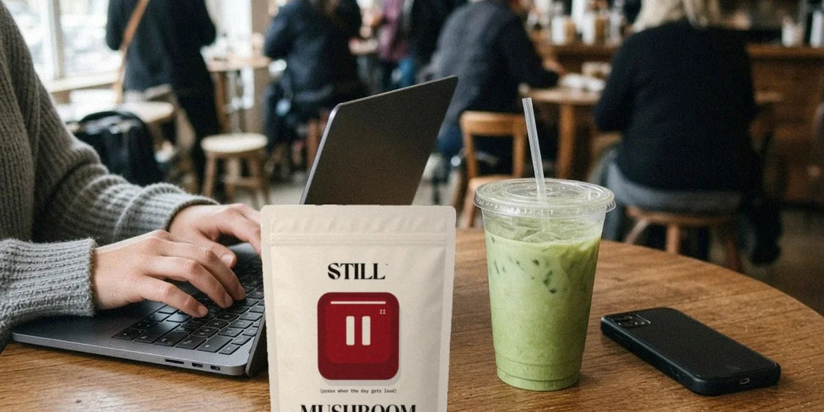 STILL Mushroom Matcha ivory pouch and an iced matcha on a café table